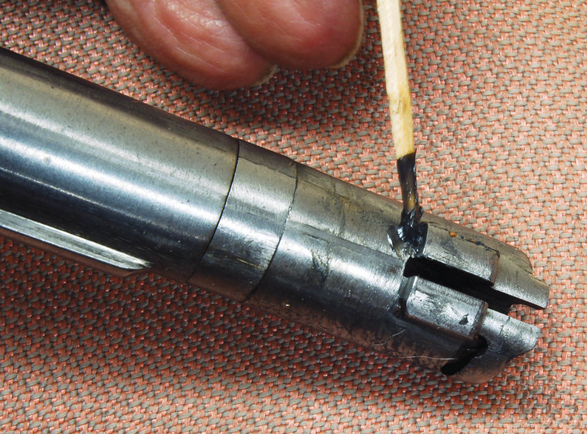 A small hump on the breechblock or the hammer (arrow) pushes the hammer back far enough  to cock. Lightly grease the underside of the breechblock.